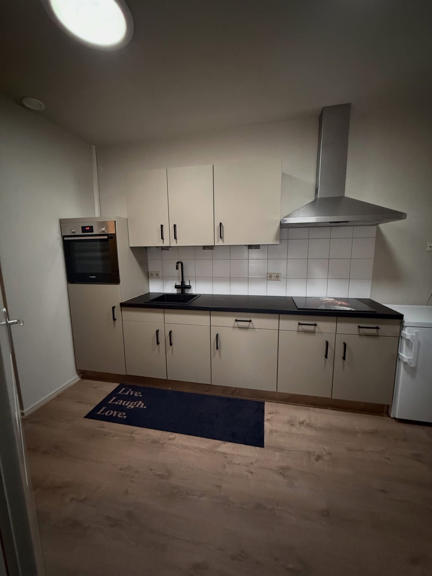 Na de keukenwrap: warme beige taupe keuken met zwart werkblad in Rucphen